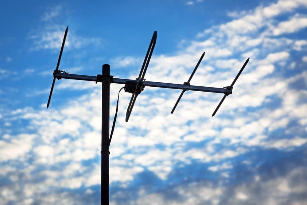 An Antenna Is Silhouetted Against A Cloudy Blue Sky — Coastwide Antennas In Avoca, NSW